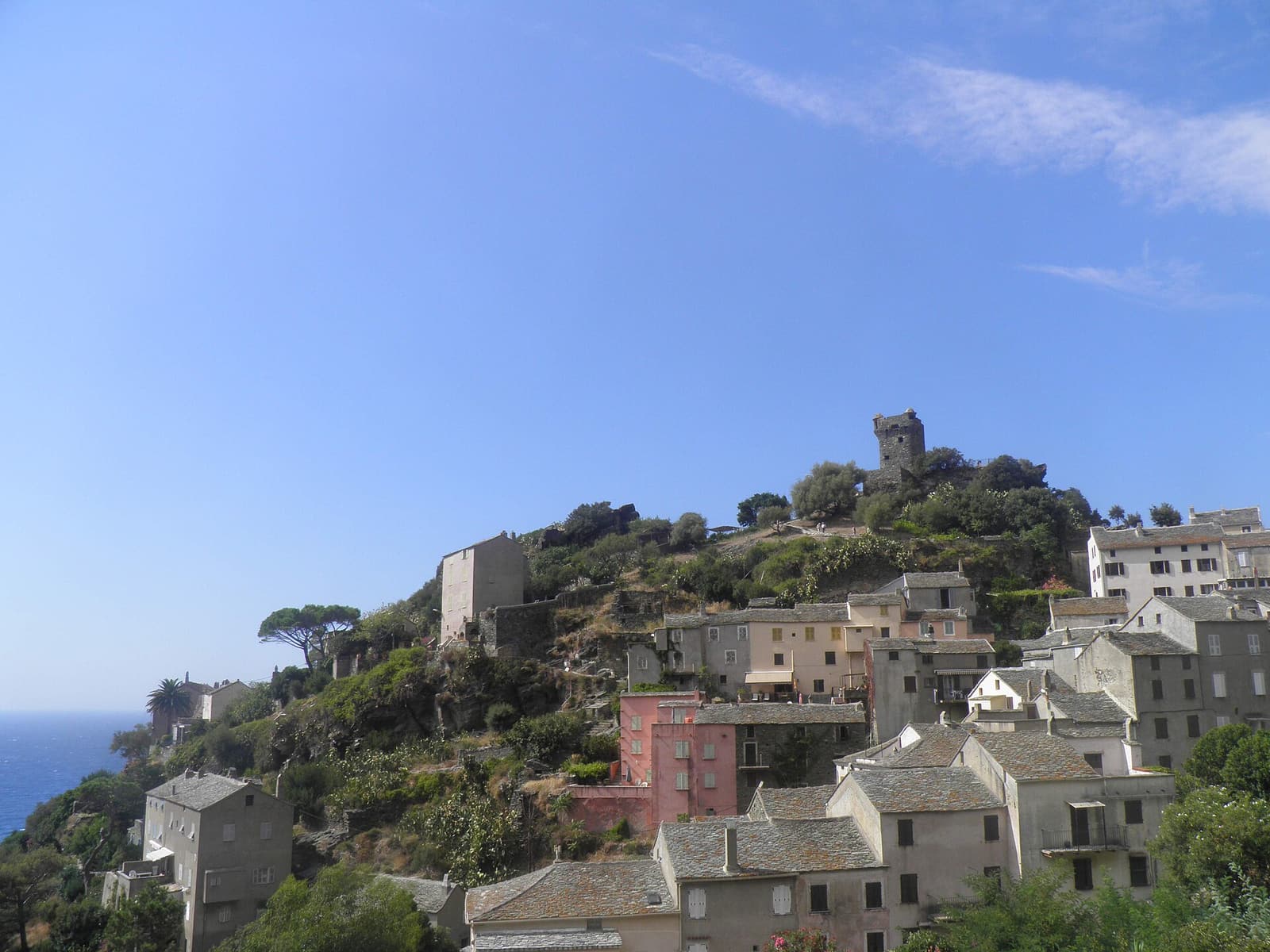 The old houses of Nonza climbing a rocky spur topped by the square Paoline tower