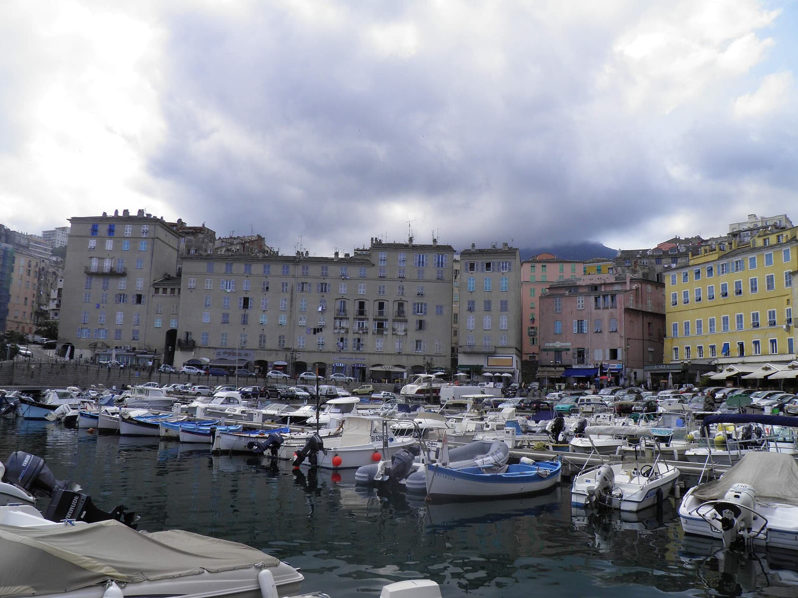 Tall, weathered houses lining the quays of Bastia’s Vieux Port, with small boats moored in front