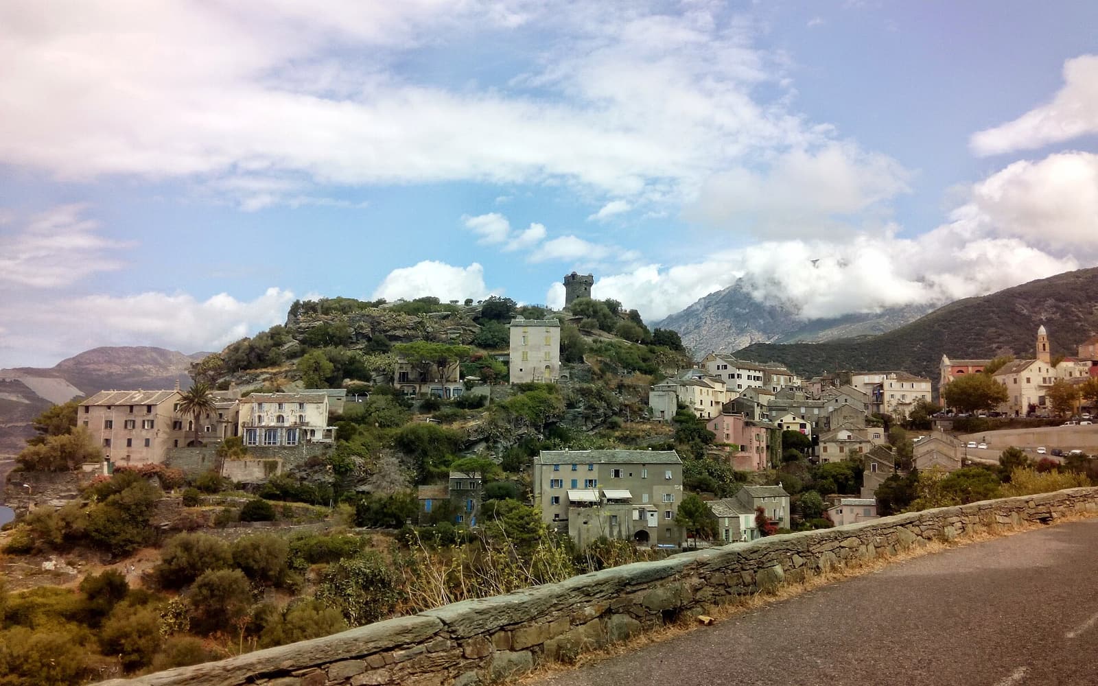 Nonza and its tower above a bend of the west-coast road