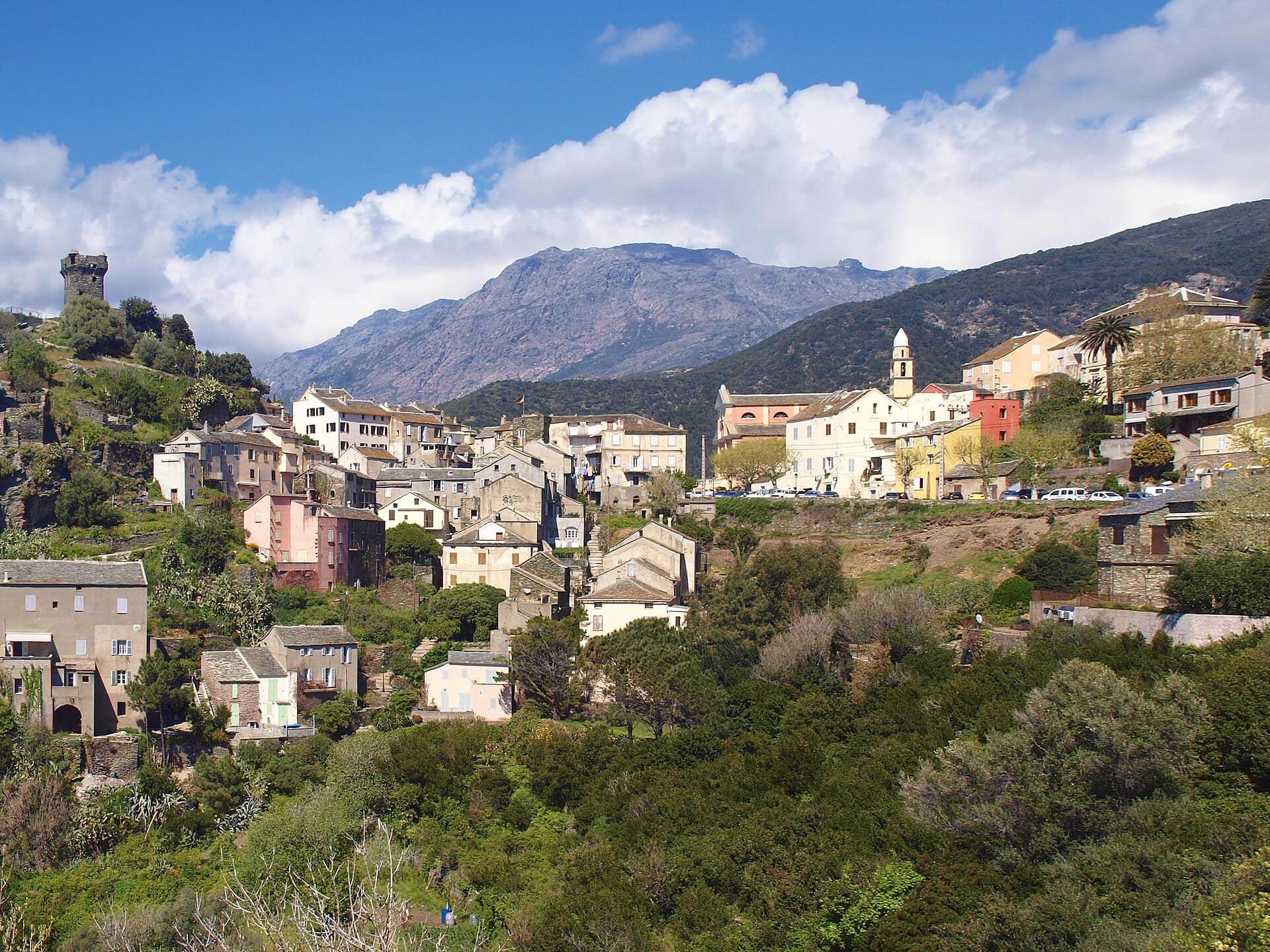 The village of Nonza and its tower on a rocky spur, with the mountains of Cap Corse behind